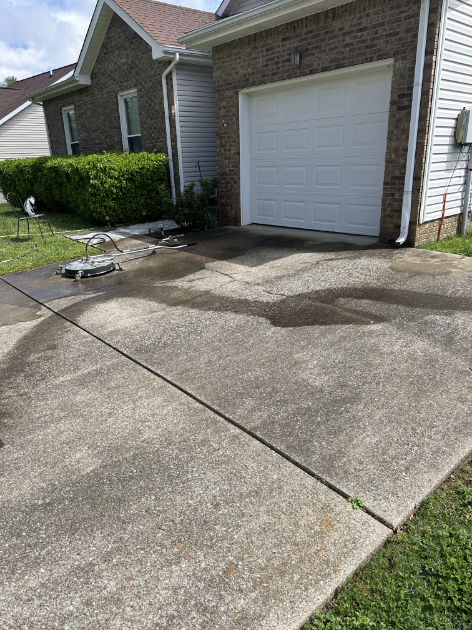 Technician performing power washing on residential property in Montgomery County TN.